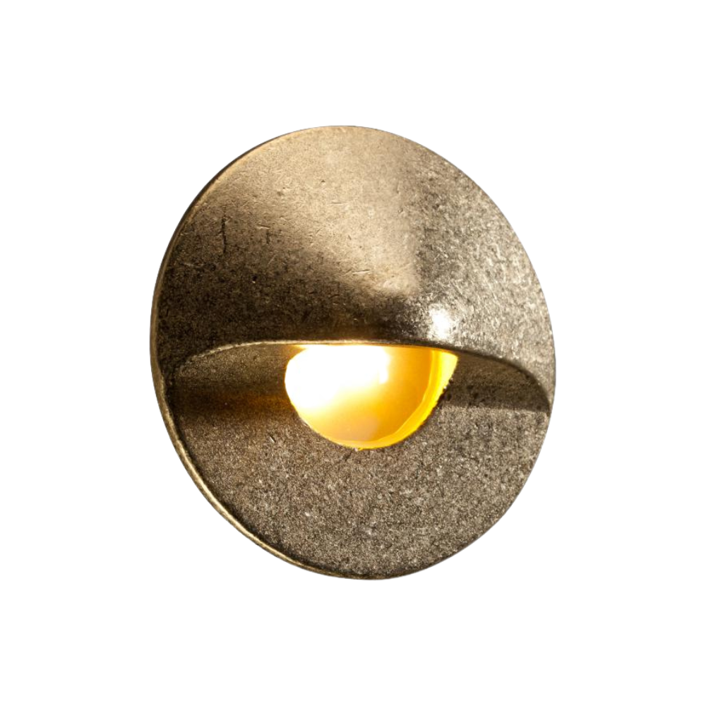FX MO hardscape LED wall light in natural brass finish, studio product shot showing round faceplate, interchangeable faceplate detail, and frosted diffuser.