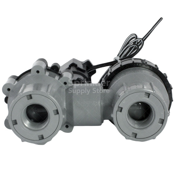 Angled view of Rain Bird 075ASVF 3/4-inch anti-siphon valve installed above ground, highlighting inlet/outlet threads, vacuum breaker cap, and solenoid connection points.