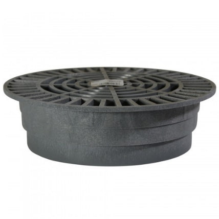 Installed view of gray NDS 1060 round grate in landscape setting, showing drainage of surface water and debris prevention.