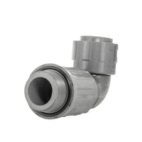 Front-facing photo of the Lasco-style 1" PVC manifold elbow with visible NUT x MVCONN threads and molded PVC body for irrigation use.
