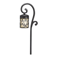 Front view of Kichler Almeria 15426BKT 12V path and spread light in textured black showing curved hood, amber glass, and landscape stake (product photo).