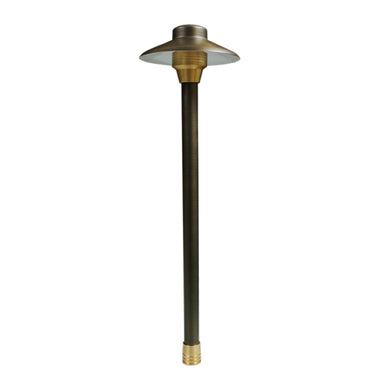 Centaurus 6-inch low-voltage path light on an 18-inch brass riser, weathered brass finish, frosted cylindrical glass lens.