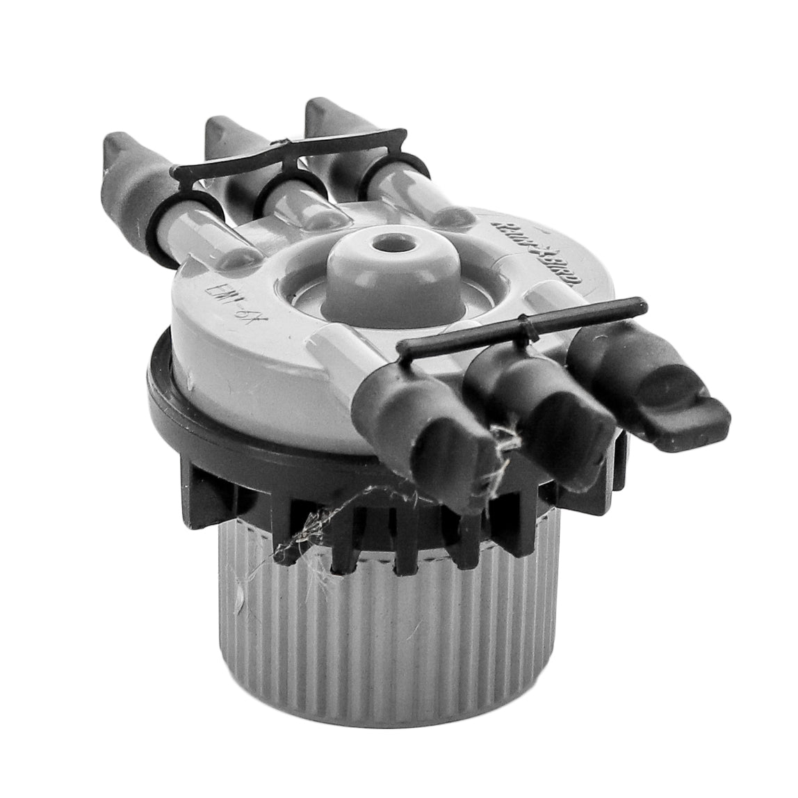 Close-up of Rain Bird EMT6XERI outlet cluster with removable plastic caps and 1/4 in barb fittings for distribution tubing.
