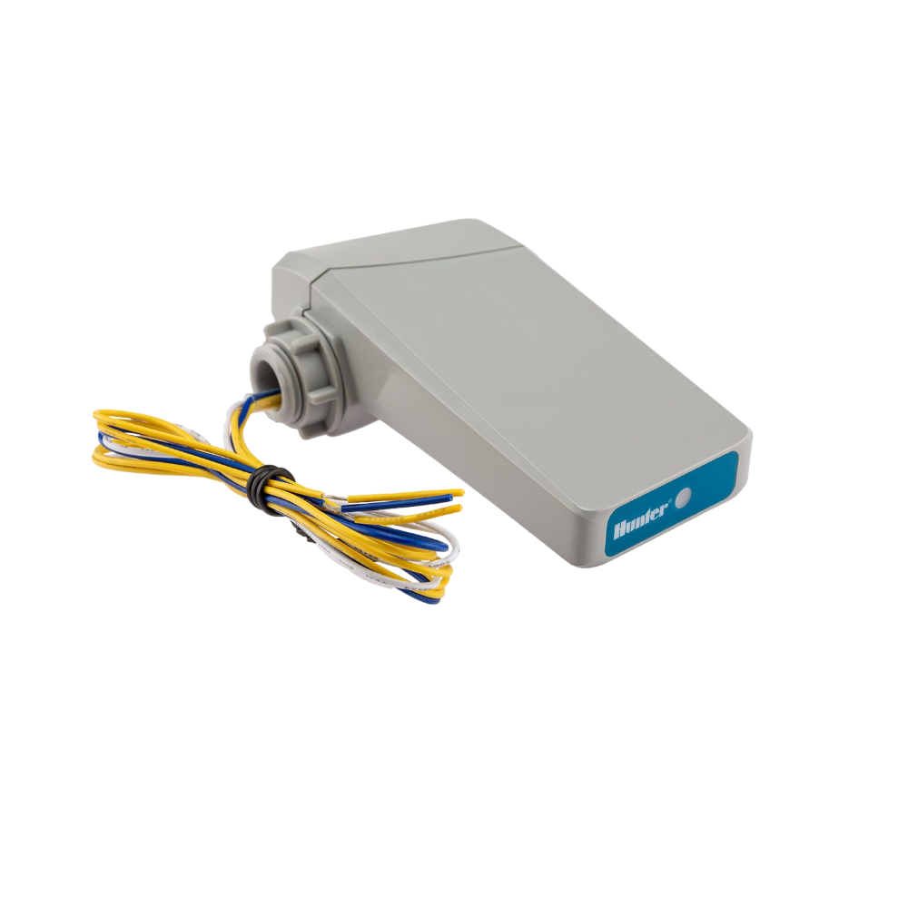 Close-up of WHCFLOW transmitter mounted in valve box, showing retainer nut, wiring connections, and battery compartment.