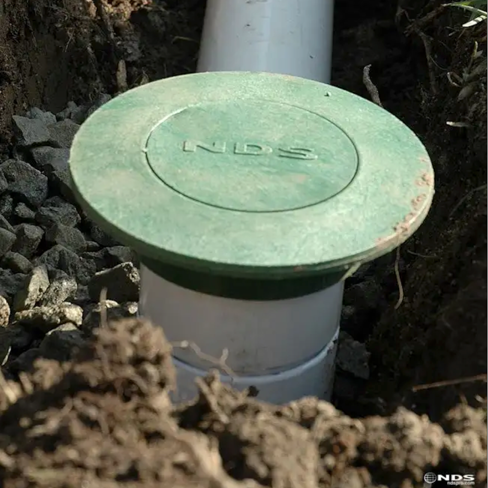 Top and side view of NDS420 pop-up drainage emitter in green plastic, designed to discharge stormwater from 3" and 4" sewer or drain pipes.