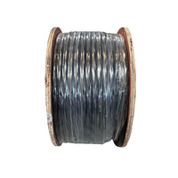 Installer handling a coiled spool of 18 AWG irrigation control wire next to valve box hardware, showing spool size and jacket details