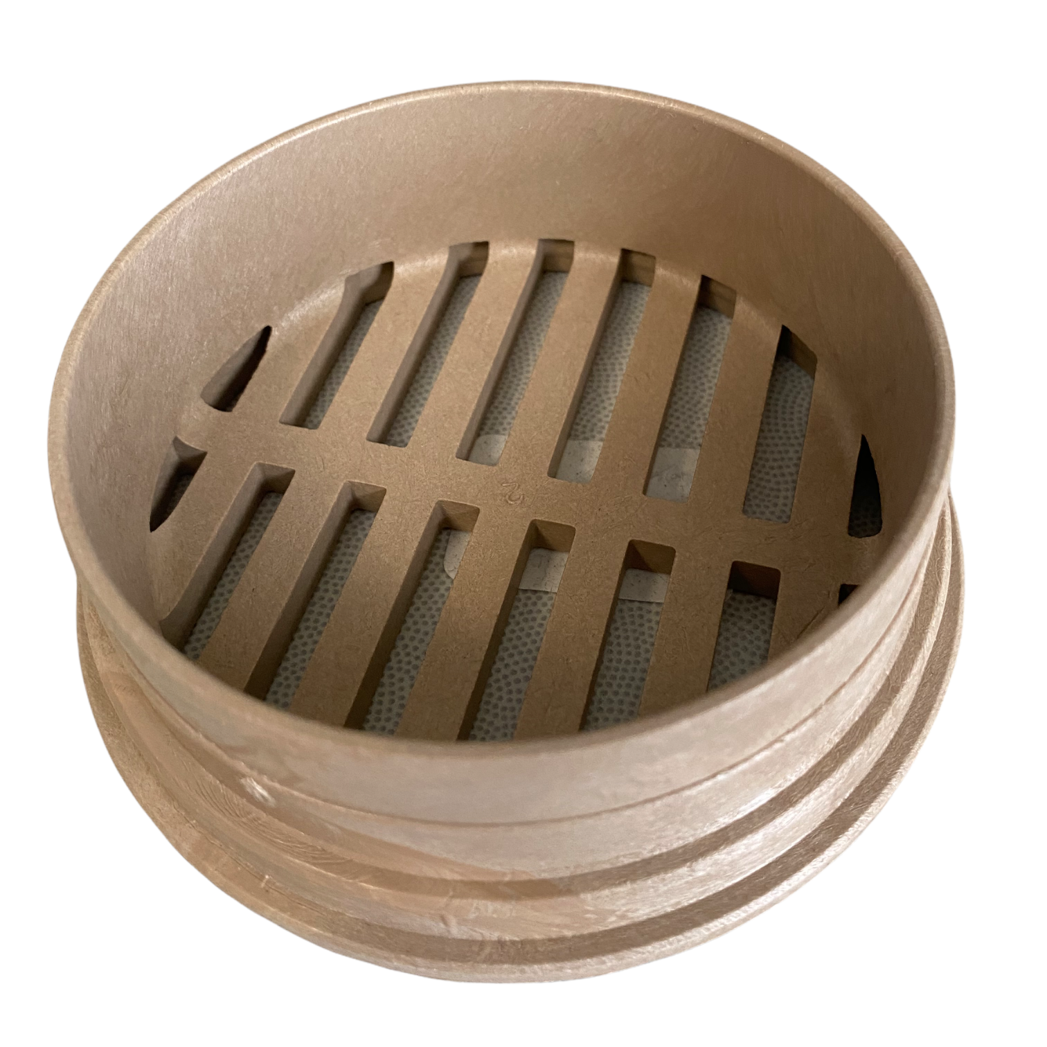 Close-up of the NDS 13S sand-colored round grate showing material texture, slotted drainage openings, and color finish.