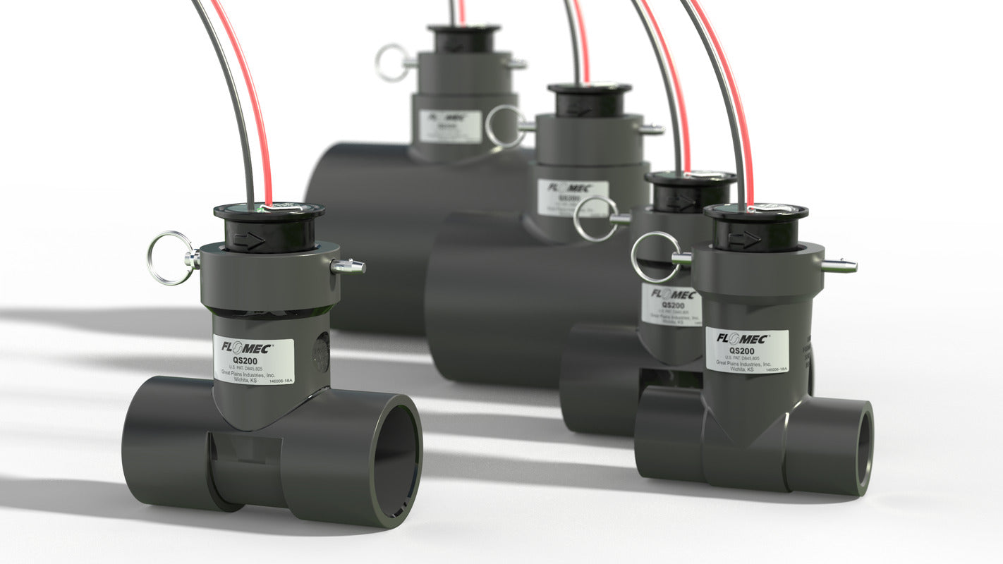 Lineup of Flomec QS200 ultrasonic flow meters in 1" to 4" Sch 80 PVC tee bodies showing size progression and patent marking.