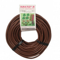 Close-up of NDS Dura Flo Jr 1/4 in dripline showing 0.5 GPH emitters spaced 6 inches on brown polyethylene, 100 ft roll.