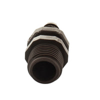 Netafim T12050MA 12mm x 1/2" male adapter placed next to 12mm dripline to illustrate fit, barbed insert, and compact one-piece design.
