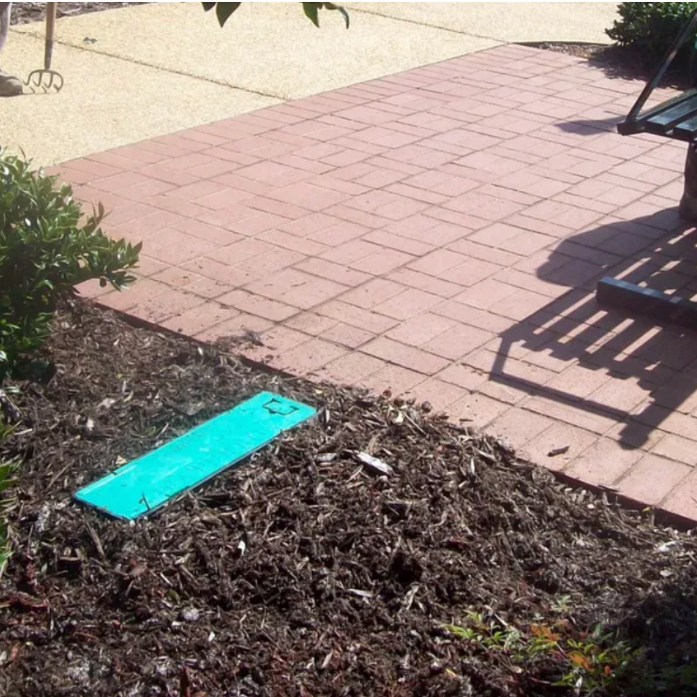 Top and side view of green WaterBox hose faucet enclosure depicting lid and compact footprint, suitable for placement near foundations or garden beds.