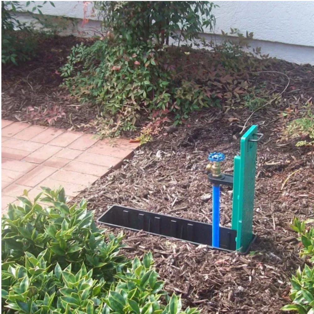 Close-up of WaterBox green plastic enclosure showing molded lid edge and sturdy construction to resist mower traffic and outdoor wear.