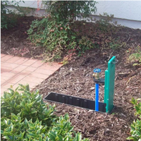 Close-up of WaterBox green plastic enclosure showing molded lid edge and sturdy construction to resist mower traffic and outdoor wear.